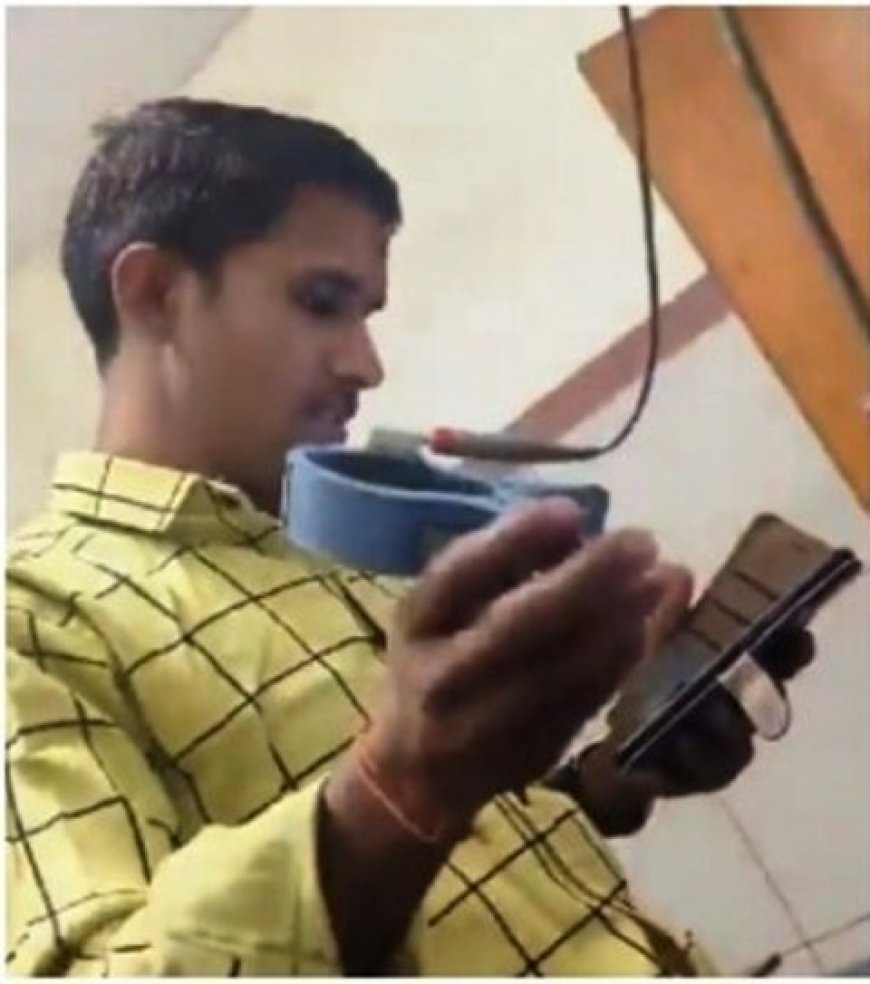 Lab attendant performs ECG on patient while watching YouTube tutorial